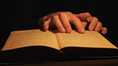 Reading an Old Book Under Vintage Yellow Lamp Lighting