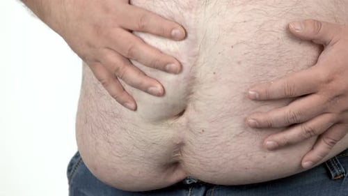 Overweight Man Touches Stomach in Studio Close Up