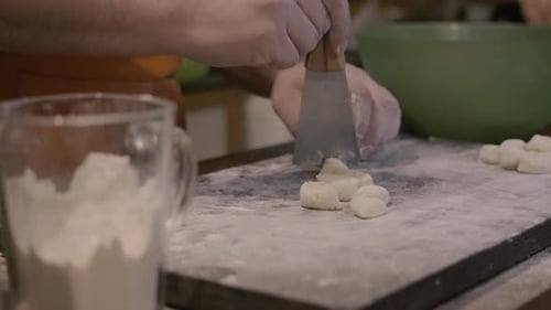 Koch schneidet Gnocchi mit Spatel in Zeitlupe