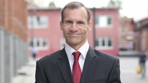 Confident Man in a Suit Smiles to the Camera