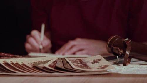 Writing in Notebook with Vintage Photos on Table