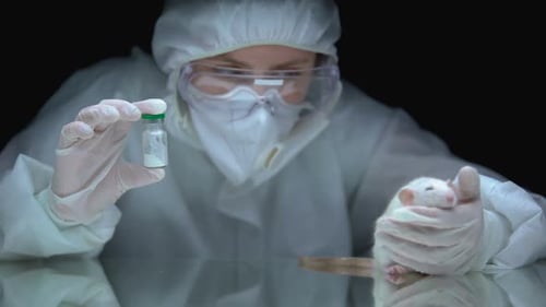 Scientist Holding Rat and Vial in Laboratory