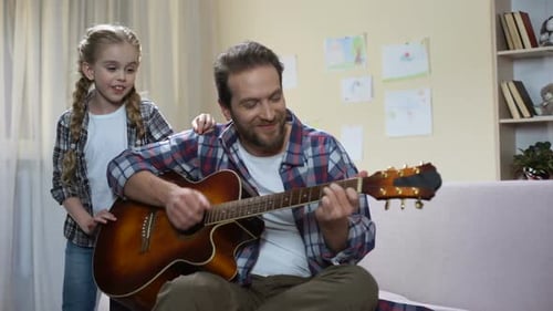 Dad and Daughter Playing Guitar Together