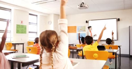 School kids raising hand in classroom