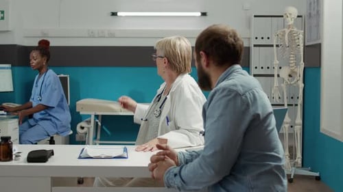 Ärztin gibt Patientin Diagnose mit Röntgen-Scan-Ergebnissen