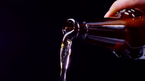 Amber Beer Bottle Pouring in Dark Setting