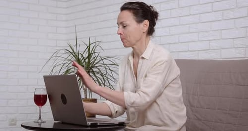 Woman at Laptop Chatting and Drinking Red Wine