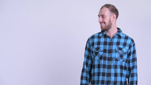 Smiling Man Points and Gestures to His Left