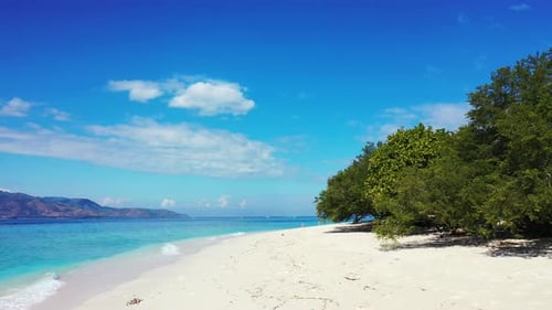Wide angle fly over tourism shot of a white paradise beach and aqua blue ocean background in high re