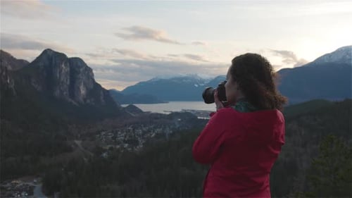 Woman Takes Pictures of Scenic Mountain Vista