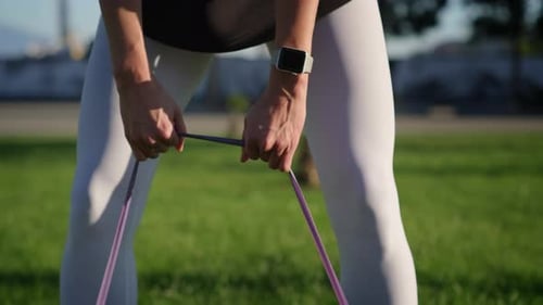 Woman Exercising with Resistance Band in Park