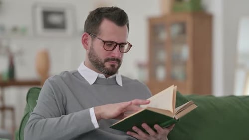 Man Reading Book Indoors During the Daytime