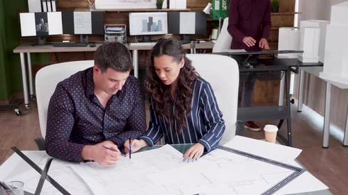 Architects Reviewing Plans Together in Modern Office