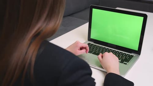 Caucasian businesswoman has video call chatting on laptop with green screen chromakey in office
