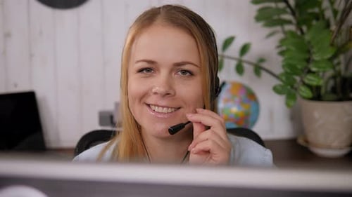 Porträt eines Callcenter-Mitarbeiters in Kopfhörern mit Mikrofon in einem Büro