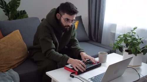Young Man Playing Synthesizer at Home