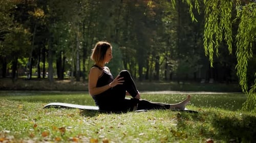 Woman Practicing Yoga Outdoors in a Park