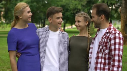 Happy Family Hugging and Smiling in Park, Posing Into Camera, Pride for Children