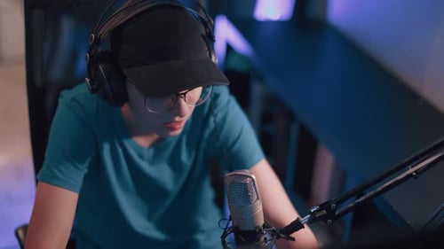 Young Adult Streaming into Microphone with Blue Lighting