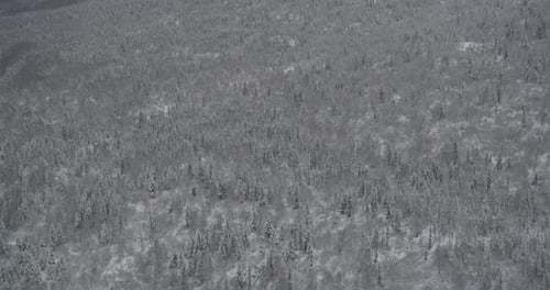 Un hélicoptère survole une montagne de pierre escarpée et révèle une vallée fluviale gelée, des images de Drone