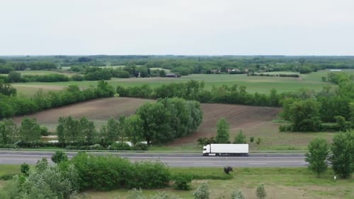 Semi-Truck on Highway Through Rural Landscape