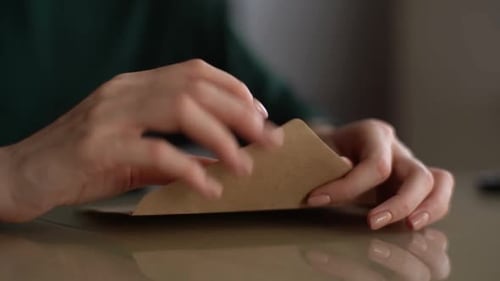 Hands Open Paper Envelope on Desk Close Up