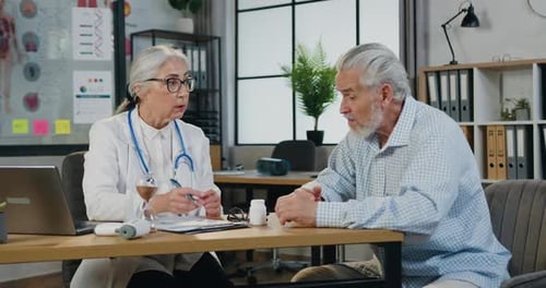 Doctor Consults with Senior Man in Office