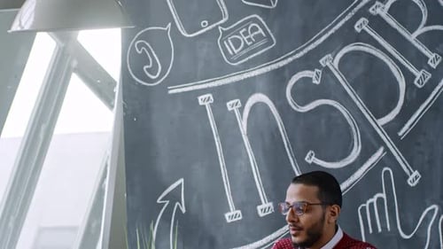 Cheerful Middle Eastern Man Working on Laptop in Creative Office