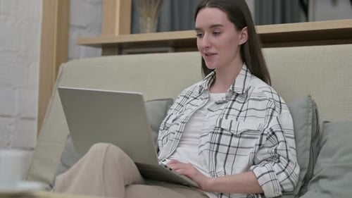 Young Woman Video Calling at Home on Laptop