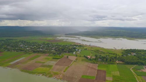 Aerial top view of forest trees and green mountain hill with lake