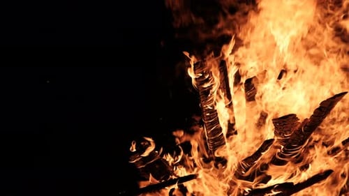 Grande fogueira queima à noite em câmera lenta em um fundo preto na natureza
