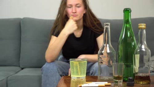 Distressed Woman Drinks Glass of Liquid