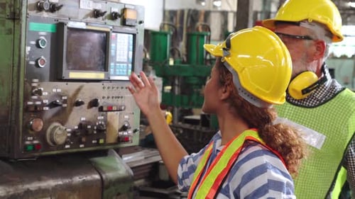 Grupo de trabajadores de fábrica que utilizan máquinas en el taller de la fábrica