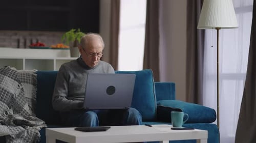 Senior Man Using Laptop Computer at Home