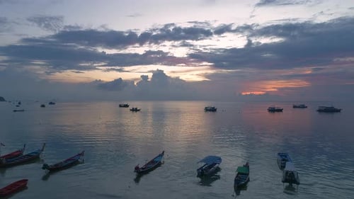 Tropical Sunset Over Calm Ocean Water with Boats