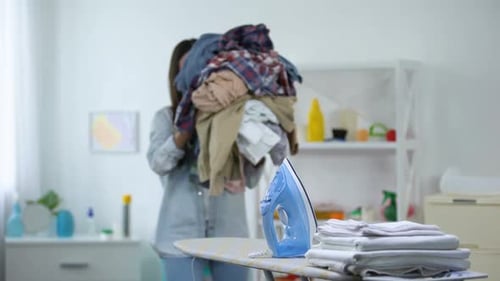 Woman Overwhelmed by Laundry in Bright Home