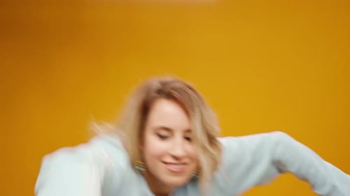 Woman Professional Dancer Dancing in Studio Against Yellow Background