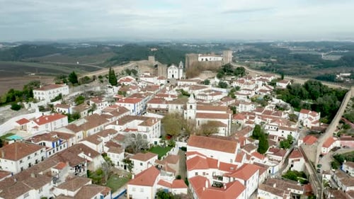 Vue panoramique des maisons blanches, des toits de tuiles rouges et du château du mur de la forteresse dans le village d'Obidos, Por