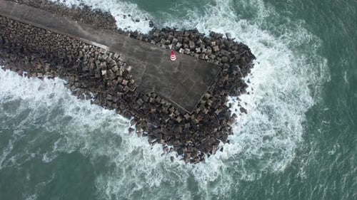 Aerial View of Pier with Waves Crashing