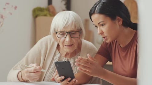 Senior Woman Learns Technology From a Young Woman