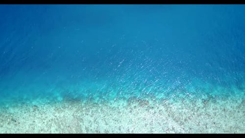 Aerial above travel of tranquil coastline beach trip by turquoise lagoon with bright sandy backgroun