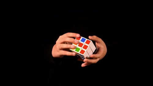 Hands Solving Colorful Rubik's Cube Puzzle
