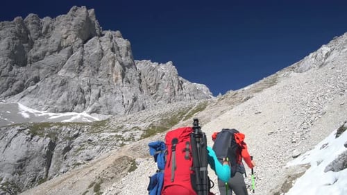 Fit Mature Couple Hikers on Stepp Difficult Way up in Mountains