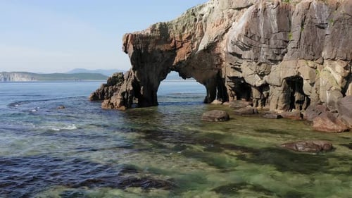Drohnenaufnahme eines Natursteinbogens am Meer