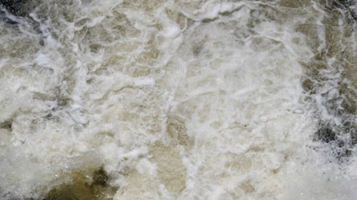 Rasender Fluss fließt mit Sedimenten beladen ab, weil