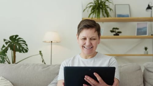 Woman Smiling and Waving During Video Call