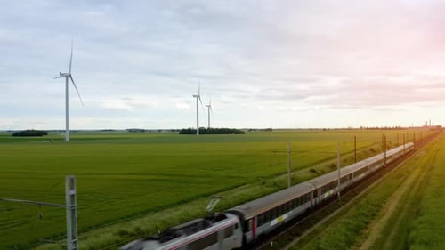 Luftaufnahme eines Regionalzuges, der durch grüne Felder fährt