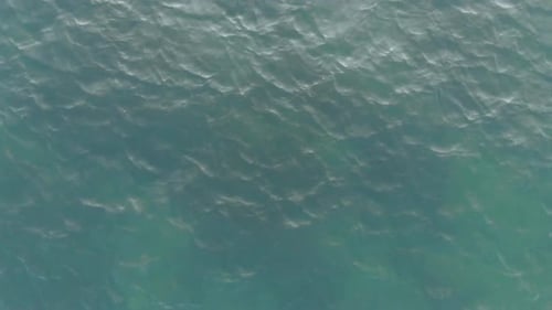 Top-down View of the Sea Waves. The Camera Flies Very High Above the Waves. Sea Ripples. Aerial View
