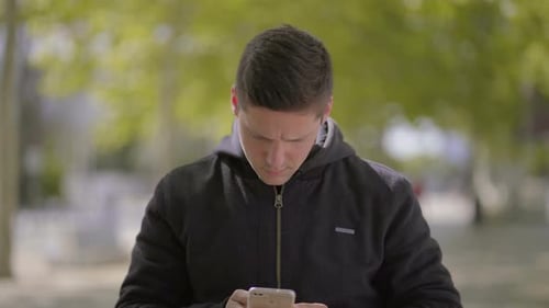 Young Adult Using Smartphone in Urban Park