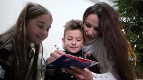 Family Writes Christmas Card Together at Home